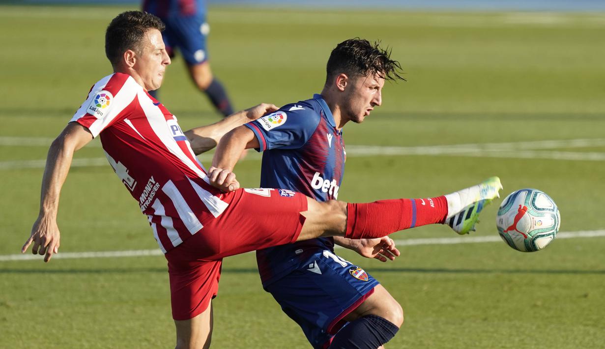 Pemain Atletico Madrid, Santiago Arias, berebut bola dengan pemain Levante, Enis Bardhi, pada laga La Liga di Stadion Camilo Cano, Selasa (23/6/2020). Atletico Madrid menang 1-0 atas Levante. (AFP/Jose Jordan)