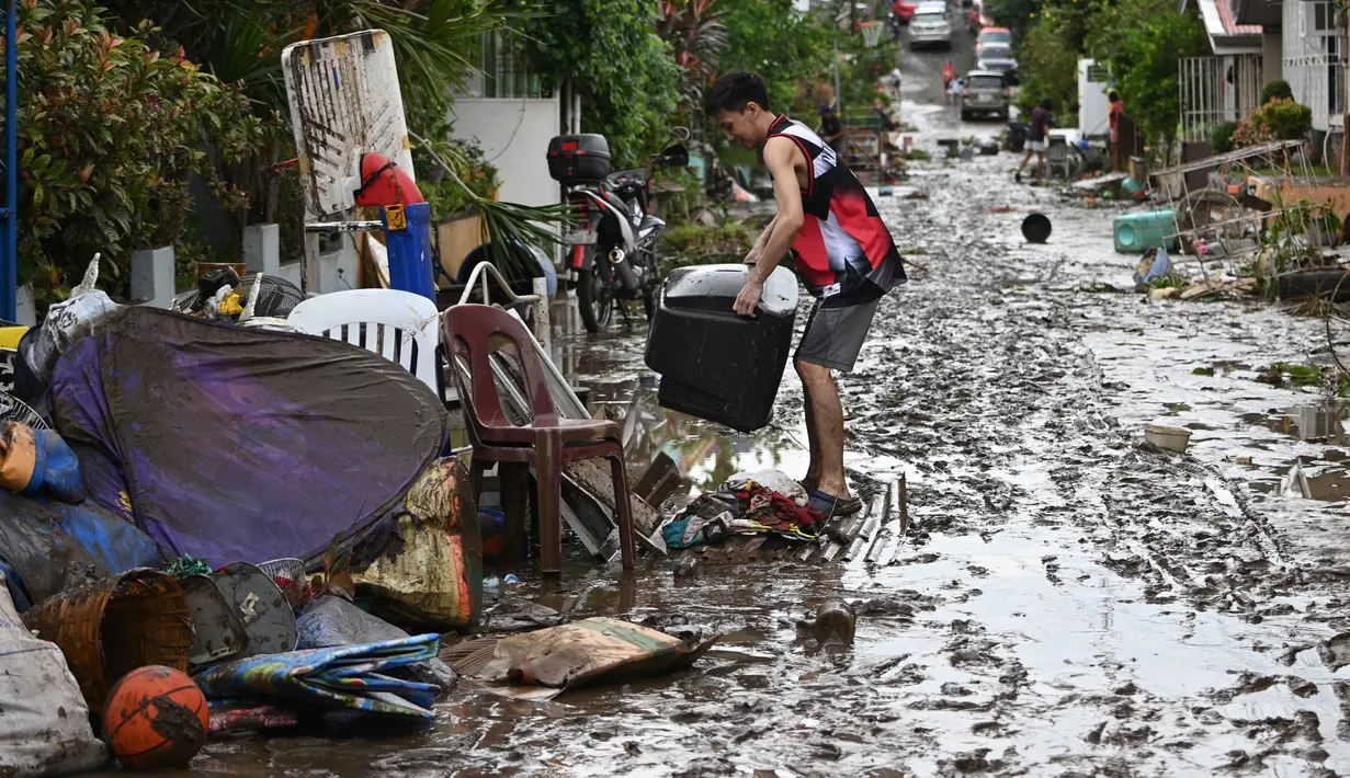 Warga membersihkan rumah mereka setelah banjir akibat Topan Goni yang melanda Kota Batangas di selatan Manila, Filipina, Senin (2/11/2020). Badan Bencana Negara mencatat sedikitnya 16 orang tewas akibat topan terkuat di dunia tahun ini, yang menghantam Filipina pada hari Minggu. (TED ALJIBE / AFP)