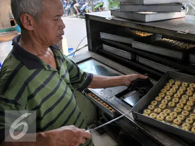 Pekerja membuat kue kering di rumah produksinya di kawasan Kwitang, Jakarta, Rabu (8/7/2015). Menjelang Hari Raya Idul Fitri permintaan kue kering mengalami lonjakan hingga 100 persen dibandingkan dengan hari biasa. (Liputan6.com/JohanTallo)
