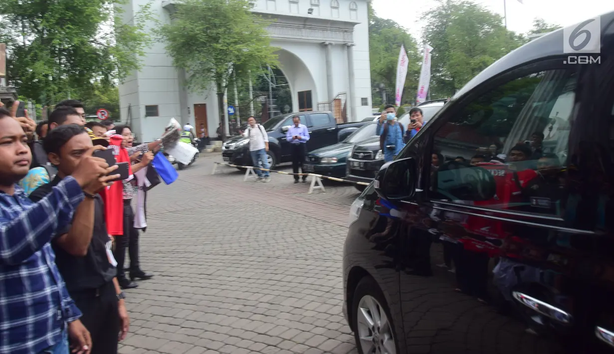 Sejumlah orang mengambil gambar mobil yang membawa mantan pesepakbola David Beckham meninggalkan SMPN 17 Semarang, Jawa Tengah, Rabu (28/3). Sempat dirahasiakan, kedatangan David Beckham ke Semarang menjadi perhatian masyarakat. (Liputan6.com/Gholib)