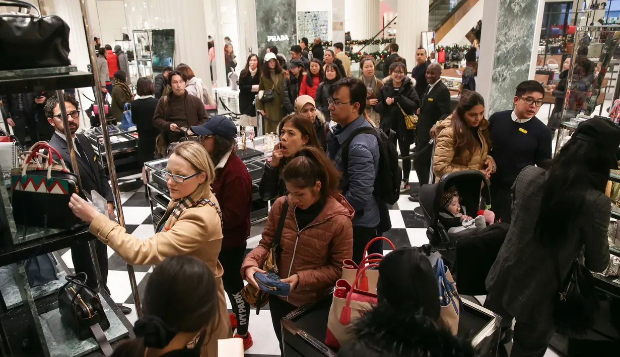 Calon pembeli mencari barang murah selama Boxing day di butik Prada, Department stores Selfridges, London, Inggris, Selasa (26/12). Boxing Day merupakan tradisi hari belanja terbesar tahunan yang dirayakan sehari setelah Natal. (Daniel LEAL-OLIVAS/AFP)
