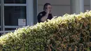 Petugas kepolisian berdiri di pintu masuk kantor pusat YouTube sesaat setelah insiden penembakan di San Bruno, California, Amerika Selatan, Selasa (3/4). Penegak hukum telah menyisir seluruh area bangunan untuk memastikan situasi telah aman (AP/Jeff Chiu)
