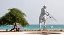 Sepasang suami istri duduk di dekat patung raksasa di tepi laut, Pulau Kish di Iran, 1 November 2016. Di pulau ini hukum Islam tidak seketat seperti tempat lainnya di Iran, dengan harapan bisa menarik mereka berkunjung. (Atta Kenare/AFP)