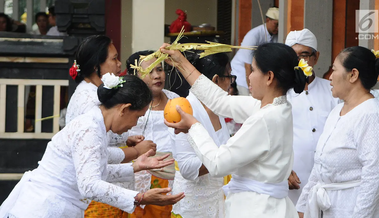 Umat Hindu memberikan air suci selama prosesi upacara mecaru di Pura Tribhuana Agung Sukmajaya Depok, Jawa Barat, Rabu (6/3). Upacara Mecaru dilaksanakan sebelum Hari Raya Nyepi pada waktu Sasih Kesanga. (Liputan6.com/Herman Zakharia)