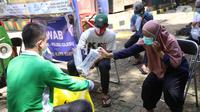 Warga memberikan kantong tes deteksi COVID-19 dengan metode GeNose C19 usai terjaring razia penggunaan masker di Kelurahan Sudimara Barat, Kota Tangerang, Kamis (27/5/2021). Tes tersebut untuk menekan penyebaran corona di wilayah tersebut. (Liputan6.com/Angga Yuniar)