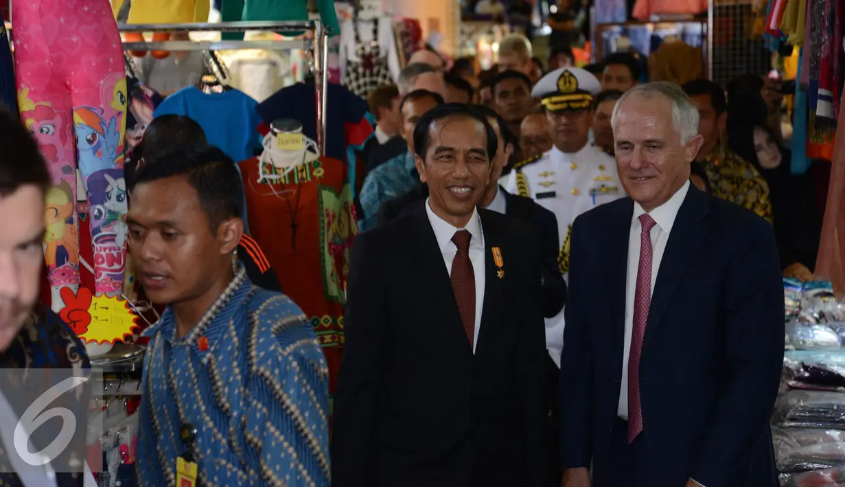 Presiden Indonesia Joko Widodo (kiri) dan Perdana Menteri Australia Malcolm Turnbull (tengah) berjabat tangan dengan pedagang saat blusukan di Blok A Pasar Tanah Abang, Jakarta, Kamis (12/11). (Liputan6.com/Faizal Fanani)
