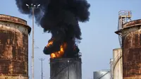 Petugas pemadam kebakaran memadamkan api di fasilitas minyak di selatan kota Zahrani, selatan kota pelabuhan Sidon, Lebanon, Senin, 11 Oktober 2021. (AP Photo)