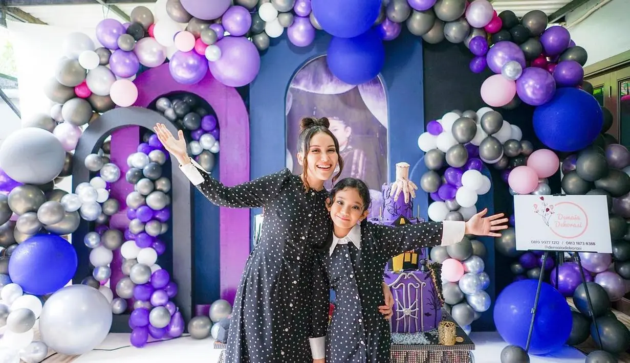 Ayu Ting Ting tampil cantik dengan dress hitam motif polkadot dengan kancing di bagian depan. Rambutnya ditata sanggul yang membentuk pita, beberapa helai rambut pun membingkai wajahnya.