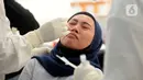Petugas medis mengambil sempel lendir salah satu peserta test SWAB massal gratis di halaman Dinas Kesehatan Tangeramg Selatan, Banten, Minggu (30/8/2020). Test Swab gratis tersebut diikuti 750 orang untuk pencegahaan penyebaran Covid-19. (merdeka.com/Dwi Narwoko)