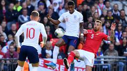 Striker Inggris, Marcus Rashford, berebut bola dengan bek Bulgaria, Nikolay Bodurov, pada laga Kualifikasi Piala Eropa 2020 di Stadion Wembley, London, Sabtu (7/9). Inggris menang 4-0 atas Bulgaria. (AFP/Ben Stansall)