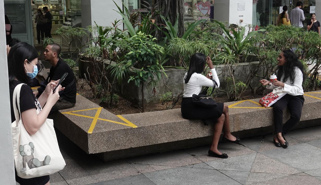 Pusat perbelanjaan menerapkan langkah social distancing atau jaga jarak sosial dengan memberikan tanda silang di area tempat duduk publik di wilayah Bugis Singapura, 28 Maret 2020. Warga di Singapura yang melanggar perintah jaga jarak akan dikenakan denda sekitar Rp 1112 juta. (Xinhua/Then Chih Wey)
