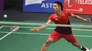 Pebulu tangkis Indonesia, Jonatan Christie mengembalikan kok saat bertanding melawan Kenta Nishimoto asal Jepang dalam semifinal tunggal putra Asian Games 2018 di Jakarta, Senin (27/8). Jonatan melaju ke final. (SONNY TUMBELAKA/AFP)