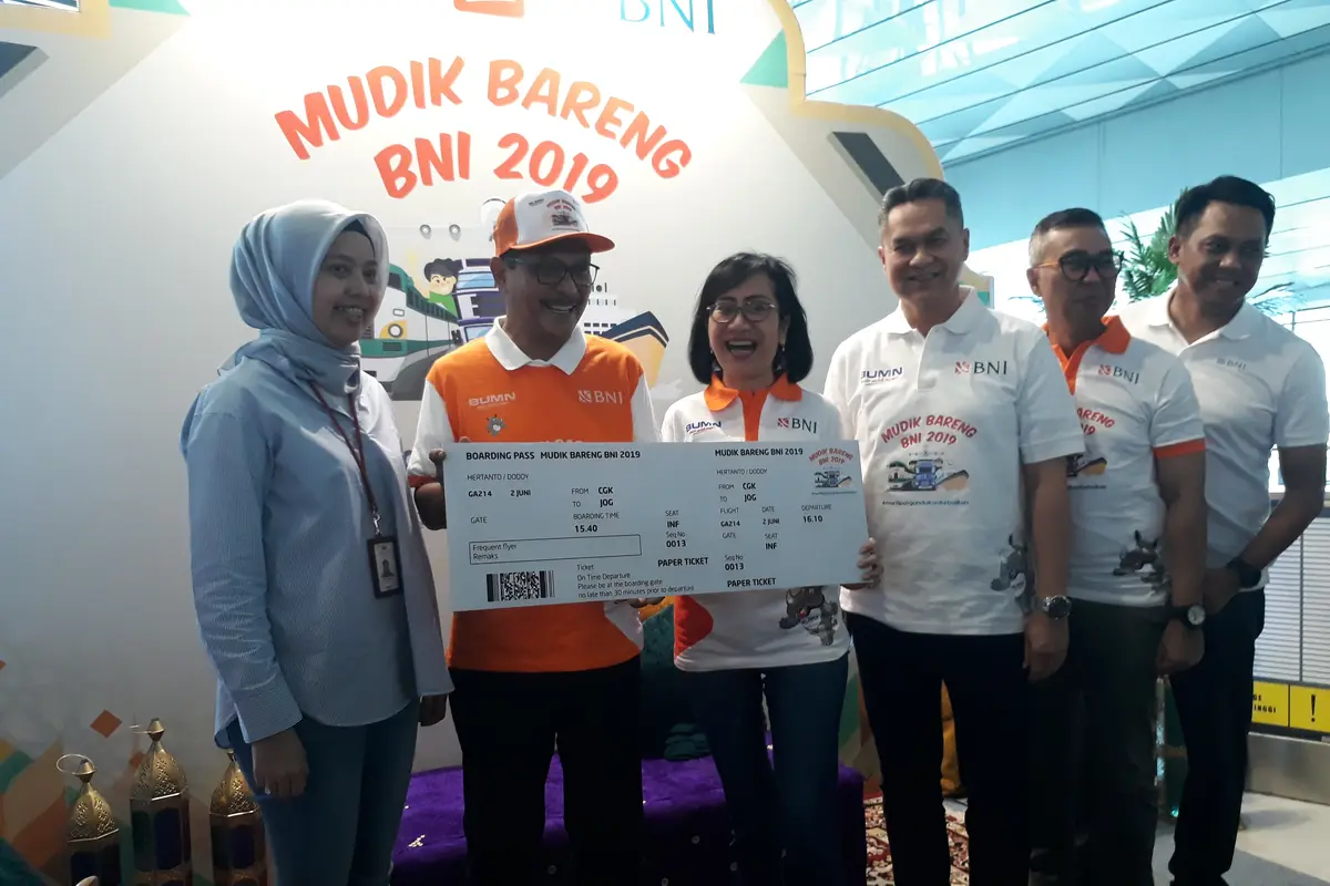 Direktur Bisnis Konsumer BNI Tambok P Setyawati (kedua kanan) menyerahkan mock-up tiket pesawat Garuda Indonesia kepada perwakilan pemudik pesawat Doddy Hertanto (kedua kiri) di Bandara Internasional Soekarno Hatta, Tangerang, Banten, Minggu (2 Juni 2019)
