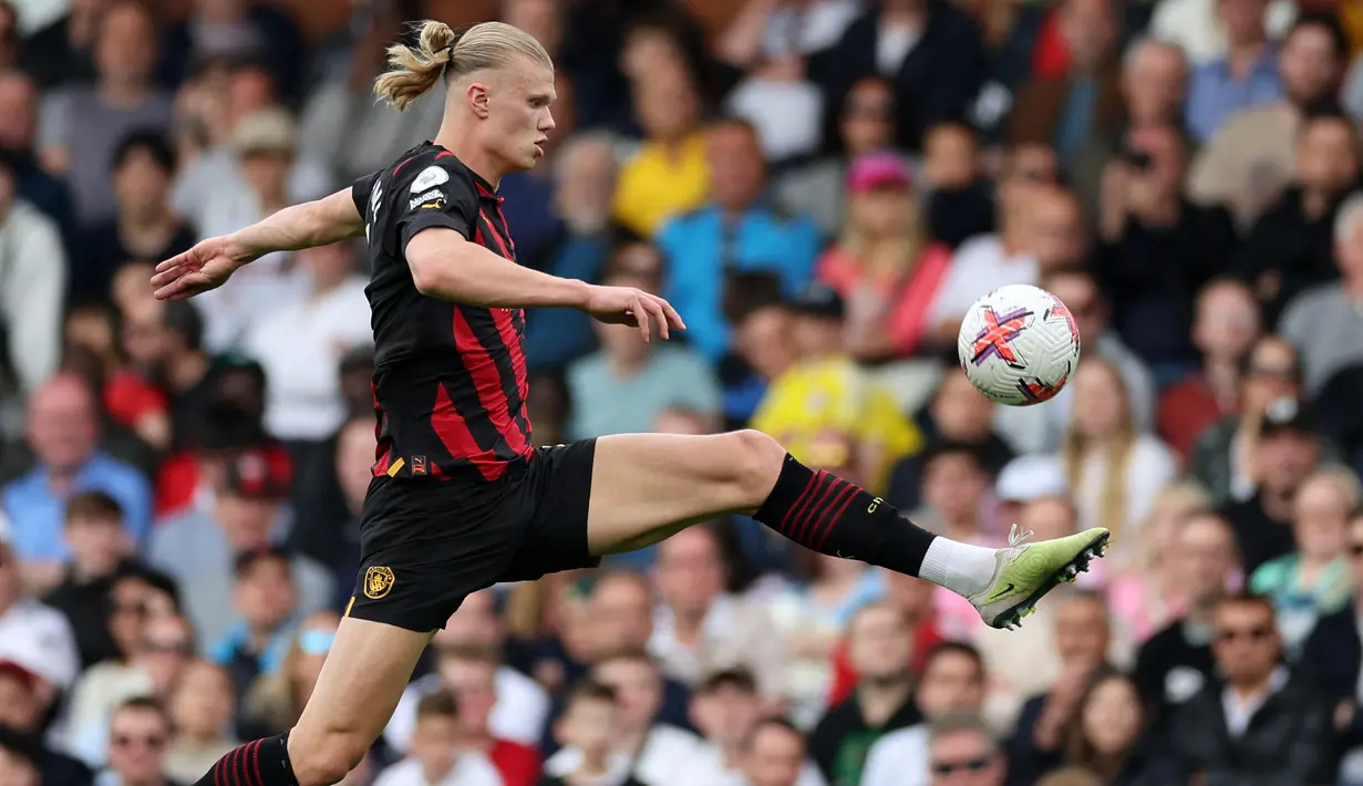 Pemain Manchester City, Erling Haaland (kiri), berusaha mengontrol bola dalam pertandingan pekan ke-34 Premier League 2022/2023 melawan Fulham yang berlangsung di Craven Cottage, Minggu (30/4/2023). Satu gol Haaland ke gawang Fulham membuat dirinya semakin kokoh di puncak daftar pencetak gol sementara dengan 34 gol. (AFP/Adrian Dennis)