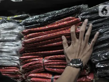 Abdullah (37) merapikan kantong plastik sekali pakai yang dijualnya di Pasar Tebet Barat, Jakarta, Selasa (30/6/2020). Jelang pemberlakuan larangan penggunaan plastik sekali pakai, Abdullah mengaku penjualan kantong kresek di tokonya menurun hingga 30 persen. (merdeka.com/Iqbal S Nugroho)