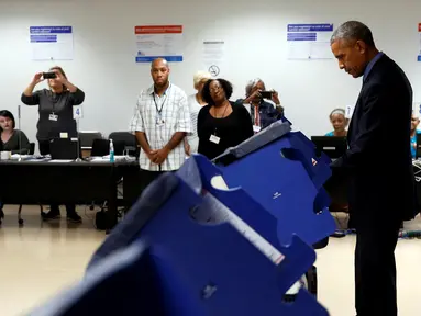 Presiden Amerika Serikat (AS) Barack Obama memberikan suaranya lebih awal untuk Pilpres AS 2016 di tempat pemungutan suara (TPS) kota Chicago, Illinois, Jumat (7/10). Chicago diketahui sebagai kampung halaman Barack Obama. (REUTERS/Jonathan Ernst)