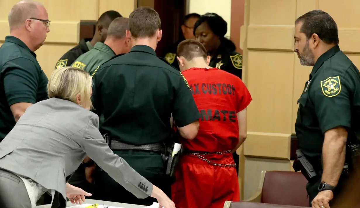 Nikolas Cruz meninggalkan pengadilan usai persidangan status hakim Broward Elizabeth Scherer di Fort Lauderdale, Florida (19/2). Cruz didakwa melakukan penembakan yang menewaskan 17 orang di SMA Majory Stoneman Douglas Florida. (AP Photo/Mike Stocker)