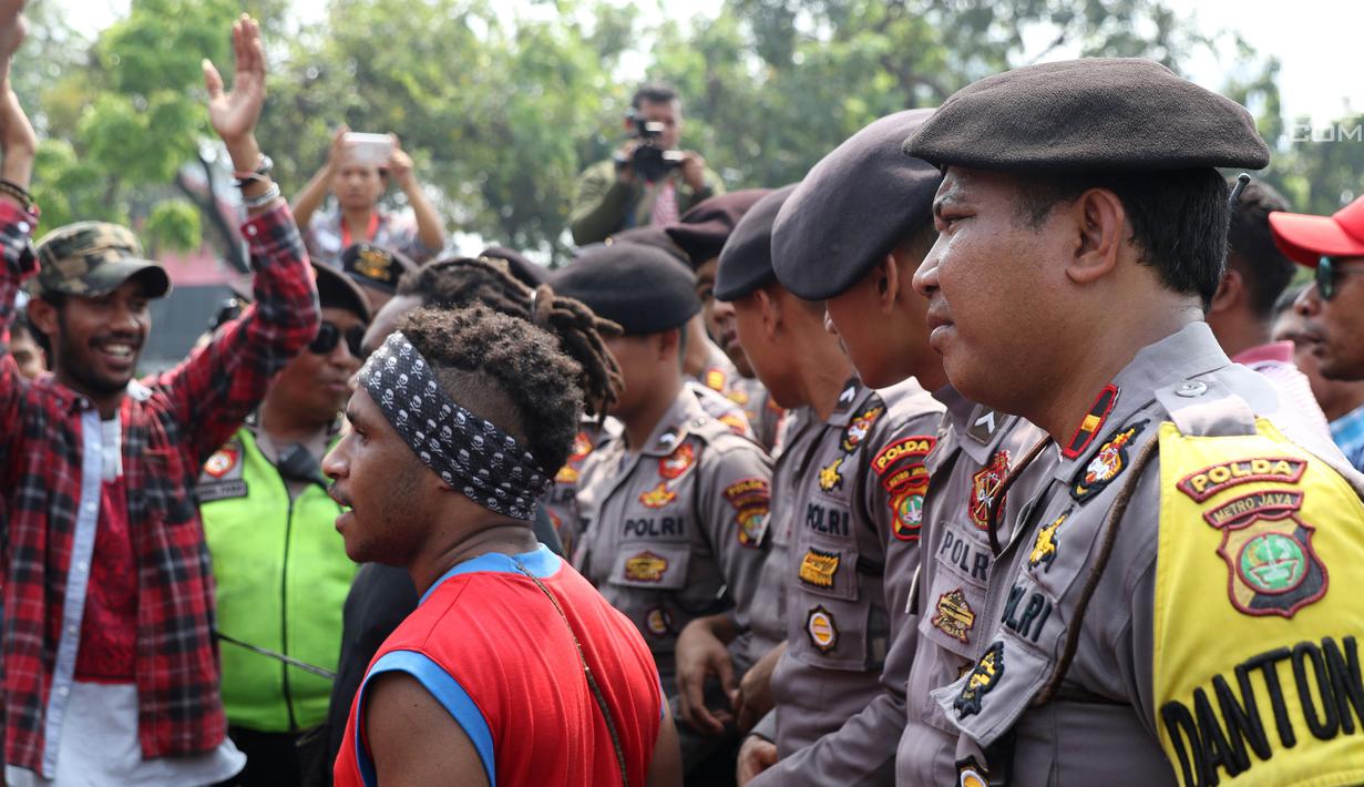 Polisi menjaga ketat aksi sejumlah pemuda Papua di kawasan depan Istana Negara, Jakarta, Kamis (2/8). Aksi ini untuk memperingati 49 tahun penentuan pendapat rakyat (Pepera) 1969. (Liputan6.com/Helmi Fithriansyah)