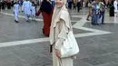 Ia juga tampil dengan abaya dan kerudung warna beige. Febby membawa tas Chanel putih dengan sling rantainya. [@febbyrastanty]