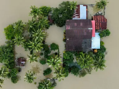 Foto udara menunjukkan sebuah rumah yang terendam banjir di Kangar, negara bagian Perlis, Malaysia utara, pada Jumat 28 November 2025. Hujan deras tanpa henti sejak awal pekan membuat aliran sungai di sejumlah wilayah Malaysia Utara meluap, hingga akhirnya merendam kawasan permukiman. (Mohd RASFAN/AFP)