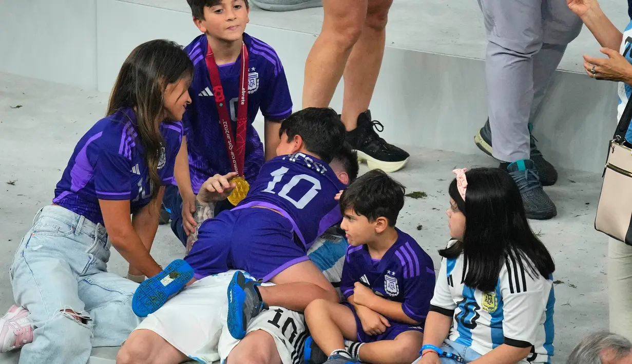 Pemain Argentina Lionel Messi memeluk anaknya saat merayakan kemenangan atas Prancis pada pertandingan sepak bola final Piala Dunia 2022 di Stadion Lusail, Lusail, Qatar, 18 Desember 2022. Argentina menang 4-2 atas Prancis melalui drama adu penalti setelah pertandingan berakhir imbang 3-3. (AP Photo/Hassan Ammar)
