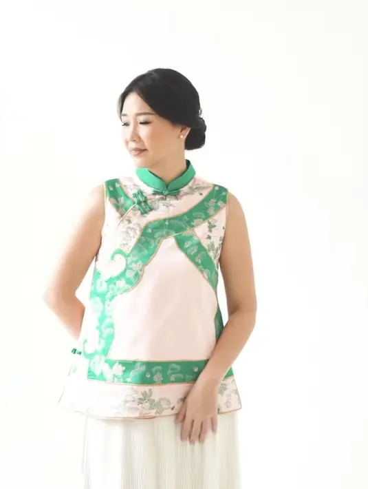 Veronica Tan melakukan photoshoot dengan tema Imlek. Ia pun mengenakan cheongsam sleeveless warna pink salur hijau. Dengan aksen kerah tinggi dan kancing shanghai. [@veronicatan_official]