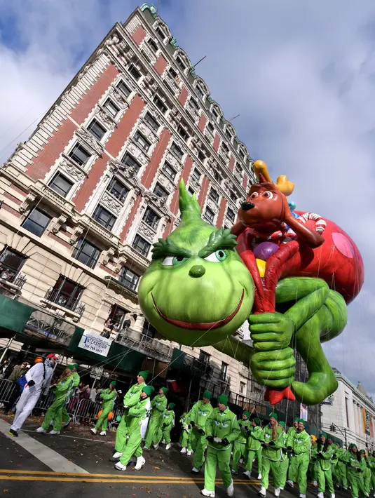Peserta menerbangkan balon  The Grinch Dr. Seuss dalam parade perayaan Hari Thanksgiving di kawasan Sixth Avenue, New York, Kamis (28/11/2019). Parade yang membelah jalanan kota New York ini selalu ditunggu setiap tahunnya. (Theo Wargo/Getty Images/AFP)