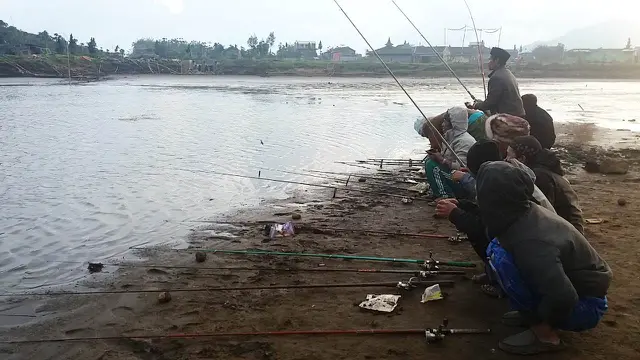 Pemancing mengadu nasib di bagian telaga yang masih berair. (Foto: Liputan6.com/Muhamad Ridlo)
