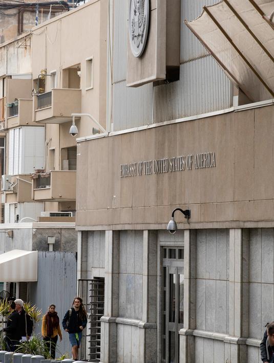 Warga berjalan di luar kedutaan AS di Tel Aviv (6/12). Kedubes AS di Israel terdapat di HaYarkon St 71, Tel Aviv-Yafo, Israel dan ada sejak akhir 1960-an. (AFP Photo/Jack Guez)