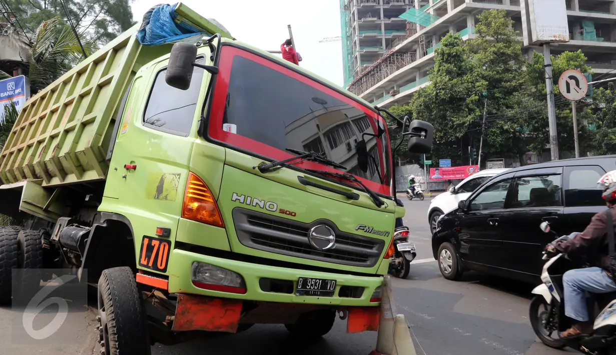 Sebuah truk bermuatan pasir menabrak lampu merah di Jalan Pejompongan, Jakarta, Minggu (14/6/2015) dini hari. Meski tidak menimbulkan korban jiwa, kecelakaan yang dipicu rem blong tersebut menyebabkan kemacetan. (Liputan6.com/Helmi Afandi)