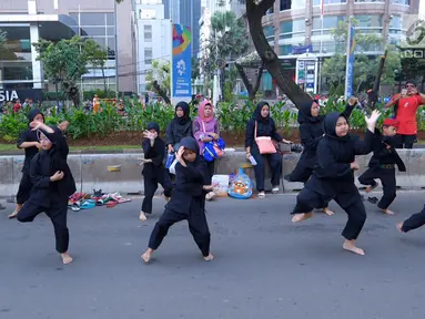 Sejumlah pendekar perempuan memperagakan jurus beladiri di hadapan warga saat Car Free Day di kawasan Senayan, Jakarta, Minggu (8/10). Aksi yang tergabung dalam Dewan Kesehatan Rakyat ini untuk memeriahkan CFD. (Liputan6.com/Fery Pradolo)