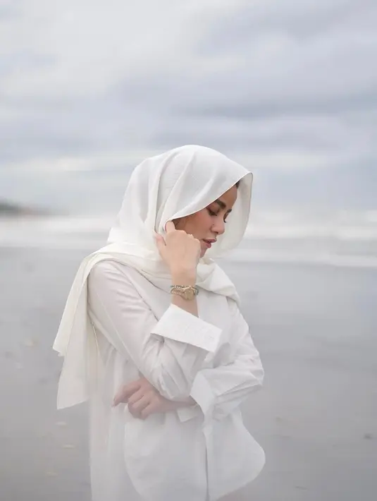 Menghadirkan kesan klasik. Nuansa serba putih jadi pilihan Olla Ramlan untuk menikmati keindahan pantai. (Foto: Olla Ramlan/ Instagram)