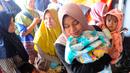 Warga antre mendapatkan pampers dan biskuit bagi anak-anak di Posko pengungsian Mangunkerta, Cianjur, Jumat (23/12/2022). Lebih dari sebulan sejak musibah gempa bumi 5,2 SR sejumlah warga masih tinggal di pengungsian dengan bantuan kebutuhan hidup dari para donatur. (merdeka.com/Arie Basuki)