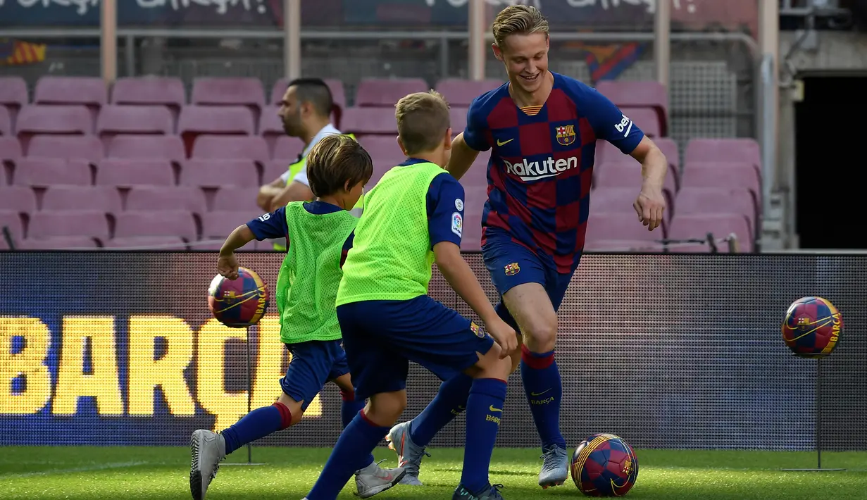 Gelandang Frenkie de Jong menggiring bola saat bermain dengan anak-anak selama pengenalan dirinya sebagai pemain baru Barcelona di stadion Camp Nou, Spanyol (5/7/2019). (AFP Photo/Lluis Gene)