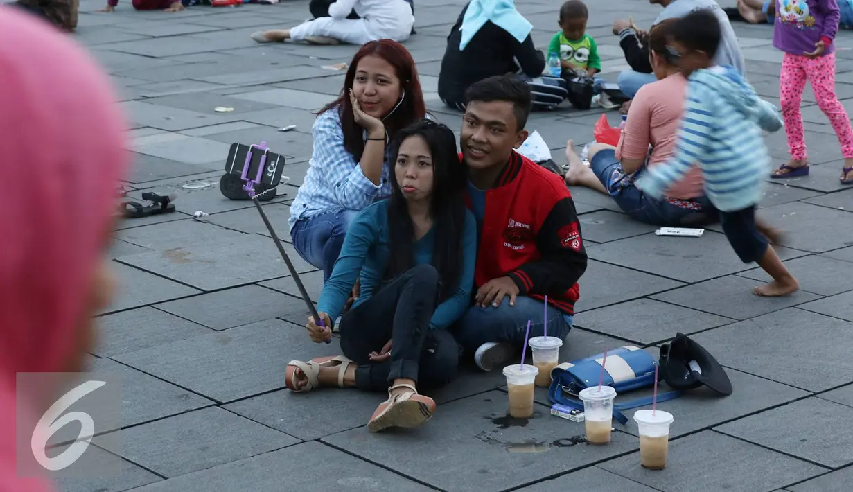 Sejumlah pengunjung berselfie di kawasan wisata Kota Tua, Jakarta, Senin (12/12). Kota Tua masih menjadi salah satu destinasi wisata bagi warga Jakarta dan sekitarnya untuk menghabiskan waktu liburan. (Liputan6.com/Immanuel Antonius)