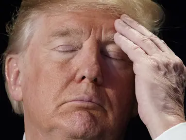 Ekspresi Presiden AS Donald Trump saat menghadiri National Prayer Breakfast atau Sarapan Doa Nasional di sebuah hotel di Washington DC (8/2). (AFP Photo/Mandel Ngan)