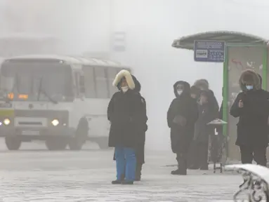 Orang-orang, kebanyakan dari mereka mengenakan masker, berdiri di halte bus saat suhu turun hingga sekitar -50 derajat (-58 derajat Fahrenheit) di Yakutsk, Rusia pada Rusia, Sabtu (16/1/2021).  Yakutsk atau Yakutia tersohor sebagai kota terdingin di dunia. (AP Photo/Tatiana Gasich)