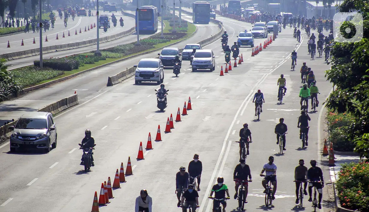 Warga berolahraga menggunakan sepeda di sepanjang Jalan Sudirman, Jakarta, Minggu (26/7/2020). Perluasan jalur sepeda sementara dilakukan sebagai dampak dari peniadaan hari bebas kendaraan bermotor (HBKB) di Jalan Sudirman-Thamrin. (Liputan6.com/Faizal Fanani)