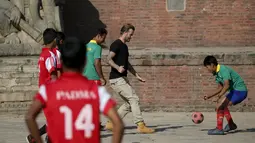 David Beckham mengoper bola ketika melakukan pertandingan amal untuk mengumpulkan dana bagi UNICEF di kota tua Bhaktapur, Nepal, Jumat (6/11). (REUTERS / Navesh Chitrakar)