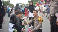 Kasat Lantas Polresta Pekanbaru Komisaris Alvin memberikan hadiah kepada anak-anak yang ikut senam zumba. (Liputan6.com/M Syukur)
