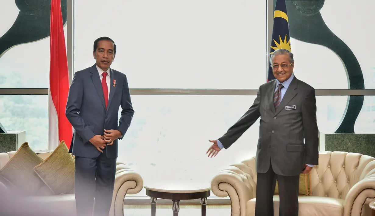 Presiden Joko Widodo dan Perdana Menteri Malaysia Mahathir Mohamad saat melakukan pertemuan di Putrajaya (8/8/2019). Pertemuan ini merupakan kunjungan balasan yang dilakukan PM Mahathir tahun lalu. (Farhan Abdullah/Department Of Information/AFP)