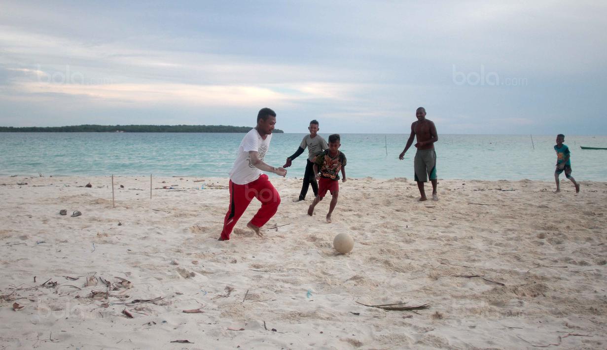 Sore hari menjadi pilihan untuk bermain bola dekat pantai di Desa Matwaer, Kei Kecil, Maluku (25/12/2017). Bermain bola di pasir menjadi daya tarik tersendiri bagi anak-anak dan pemuda desa. (Bola.com/Nick Hanoatubun)