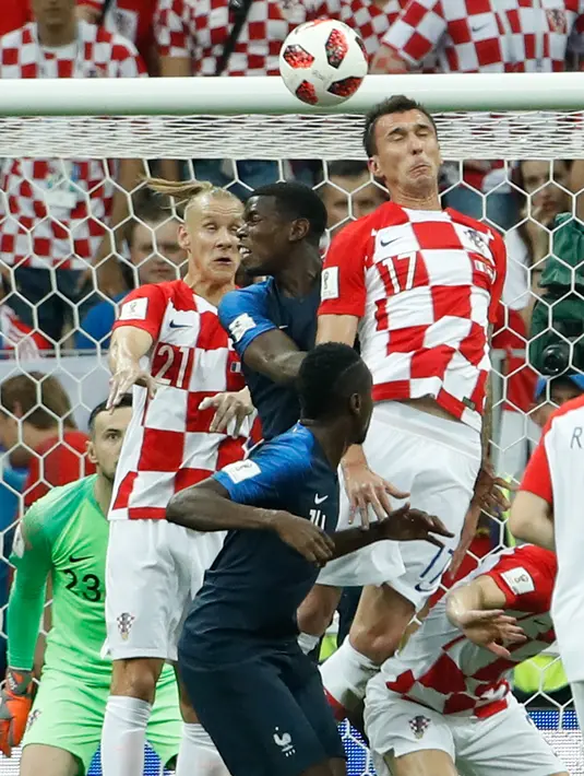 Pemain depan Kroasia Mario Mandzukic (kanan) menyundul bola dan mencetak gol bunuh diri setelah tendangan bebas pemain Prancis Antoine Griezmann pada pertandingan final Piala Dunia 2018 di Stadion Luzhniki Moskow, (15/7). (AFP PHOTO / Ganda Andersen)