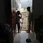 Dua orang anak bermain di depan pintu rumahnya yang terhimpit bangunan gudang di kawasan Mangga Dua Dalam, Jakarta, Kamis (12/12/2019). (Liputan6.com/Herman Zakharia)