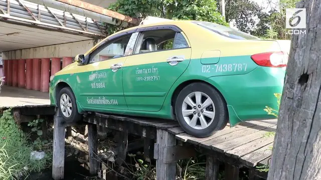 Sebuah taksi tersangkut di jembatan kayu di Thailand. Peristiwa itu terjadi saat sopir akan menjemput penumpang di wilayah  Chachoengsao.