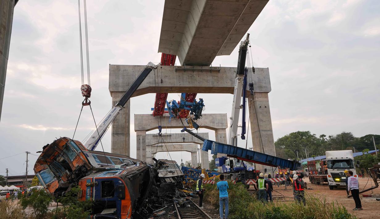 Tim penyelamat harus menggunakan peralatan pemotong logam untuk membuka badan gerbong yang ringsek dan mengevakuasi korban. Tampak dalam foto, pemandangan setelah sebuah crane atau derek konstruksi jatuh ke kereta penumpang di provinsi Nakhon Ratchasima, Thailand, Rabu 14 Januari 2026. (AP Photo/Sakchai Lalit)