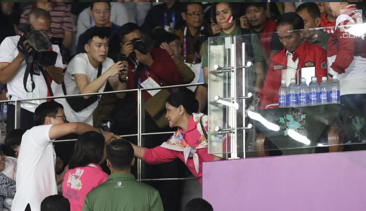 Ibu Negara, Iriana Joko Widodo (tengah) menyalami warga usai menyaksikan final bulutangkis beregu putra Asian Games 2018 antara Indonesia melawan China di Istora Kompleks GBK, Jakarta, Rabu (22/8). Indonesia kalah 1-3. (Liputan6.com/Helmi Fithriansyah)