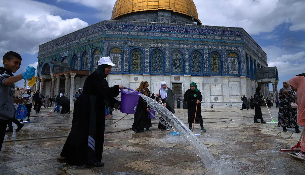 Para relawan menyikat lantai kemudian membilasnya dengan air. (AP Photo/Mahmoud Illean)