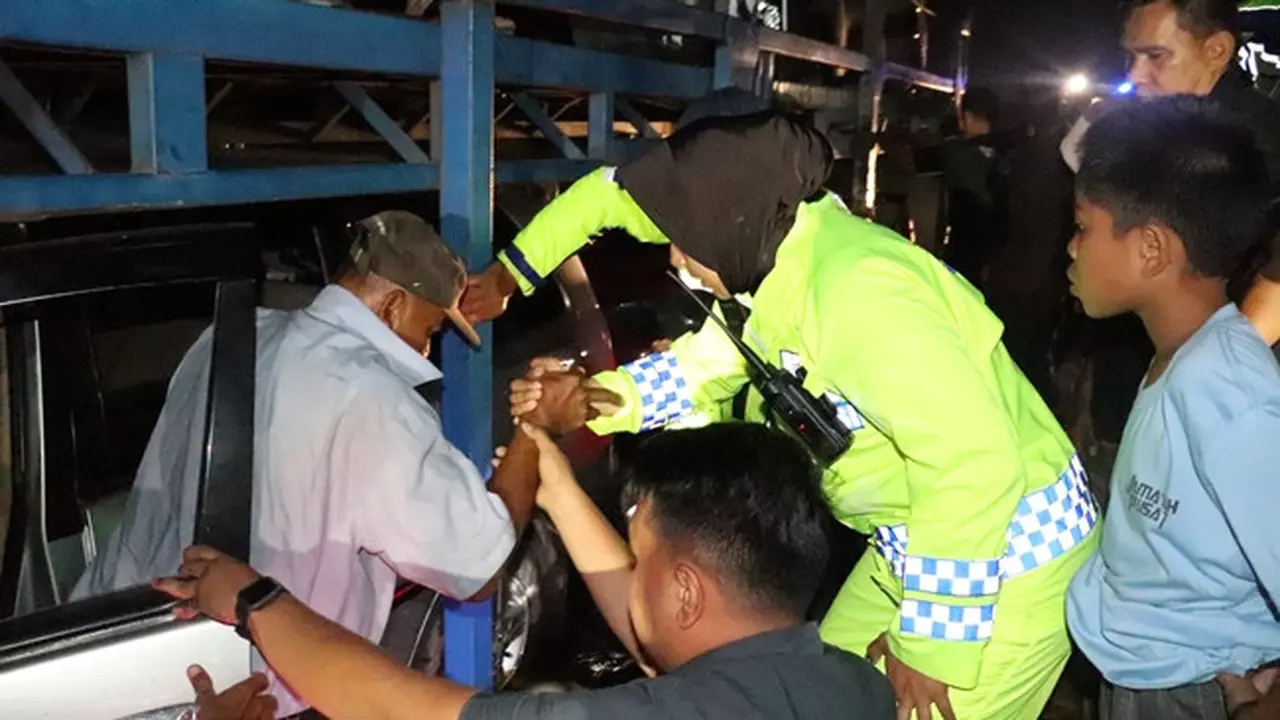 Kasat Lantas Polres Pelalawan AKP Akira Ceria membantu evakuasi pengendara yang terjebak banjir Jalan Lintas Timur.