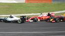 Pebalap Ferrari, Sebastian Vettel, bersenggolan dengan pebalap Mercedes, Nico Rosberg (kiri), saat balapan F1 GP Malaysia di Sirkuit Sepang, Minggu (2/10/2016). (AFP/Mohd Rasfan)